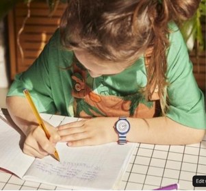 Enfant qui s’exerce à écrire sur une feuille lignée
